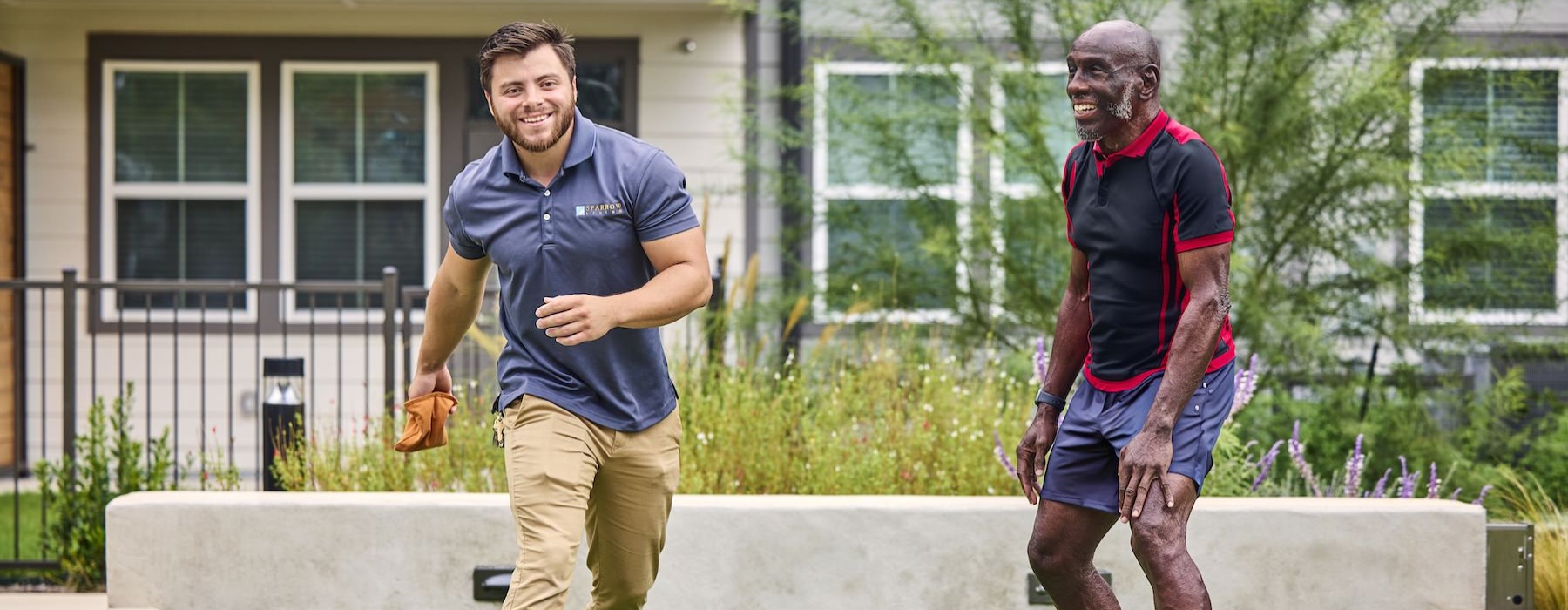 a couple of men playing cornhole